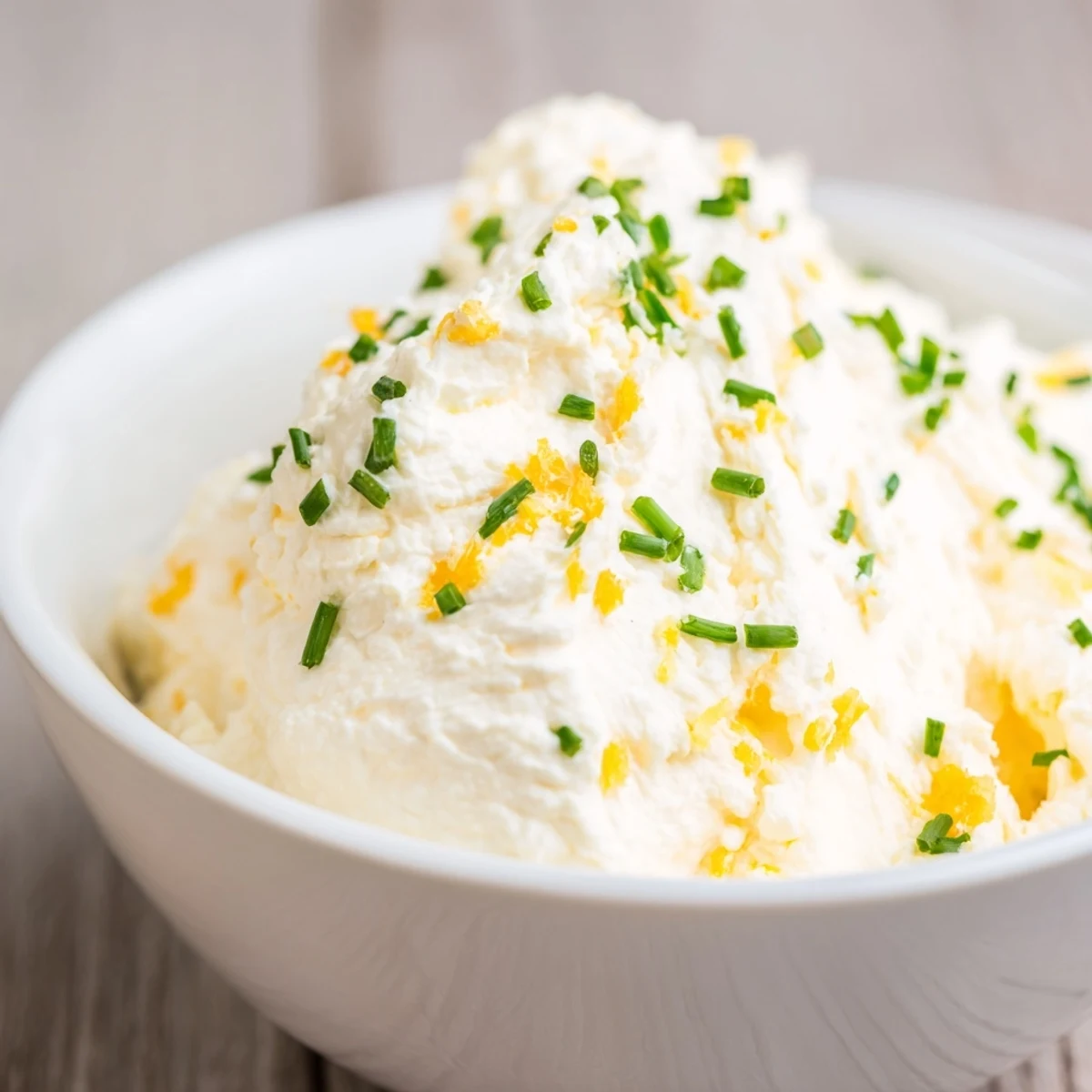 A smooth, tangy Creamy Cheese with Crackers spread featuring cheddar and chives, scooped onto a whole wheat cracker, ready for a quick savory snack.