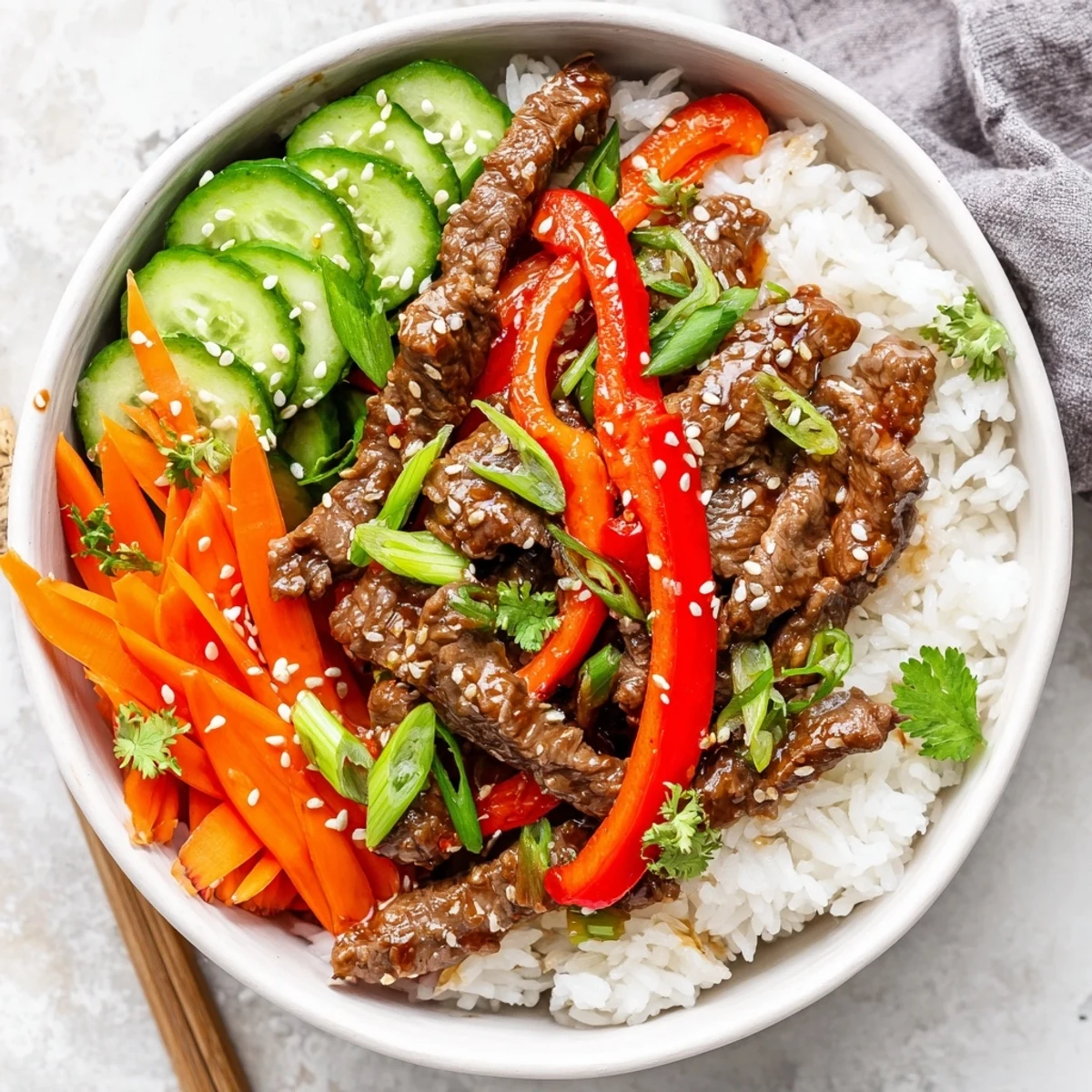 Golden beef strips, crisp red bell peppers, and snap peas stir-fried in savory sauce atop fluffy jasmine rice, ready to serve.