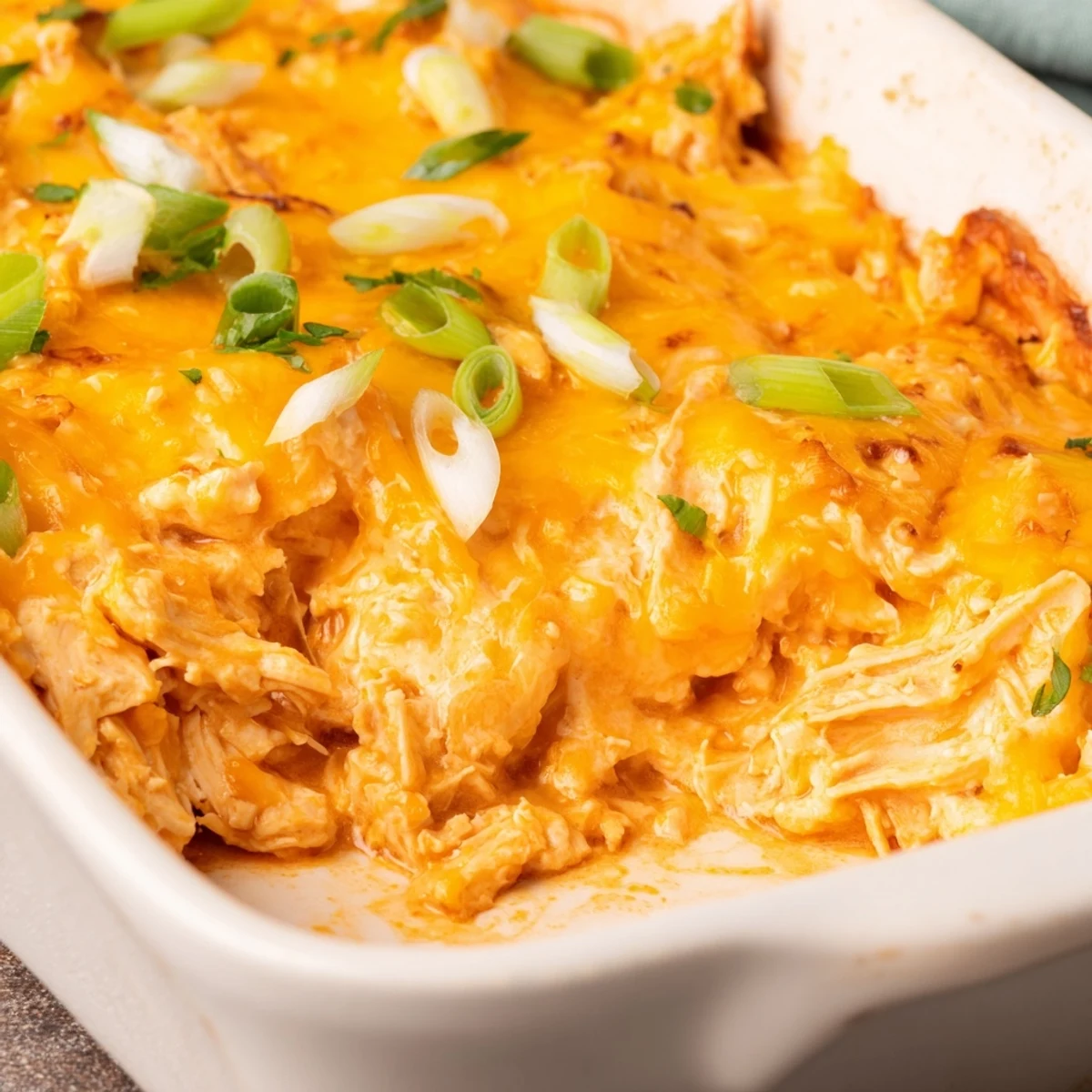 Spicy Buffalo Chicken Dip with Tortilla Chips baked golden and bubbly in a dish, steam rising from the melted cheese and spicy red sauce.