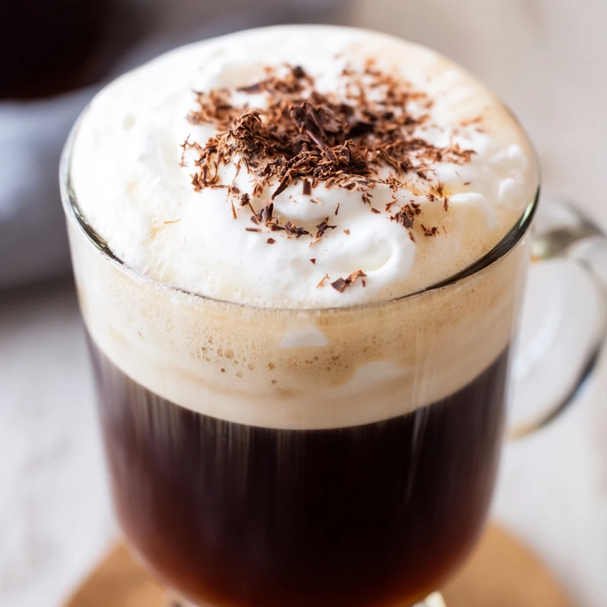Creamy Irish Coffee Mocktail topped with softly whipped heavy cream and a dusting of nutmeg in clear mugs.  