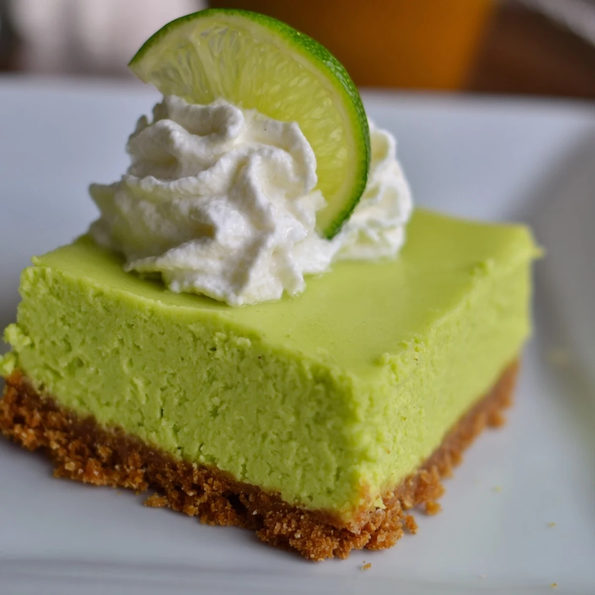 Vibrant green St. Patrick's Day Key Lime Pie Bars are sliced and served on a white plate.