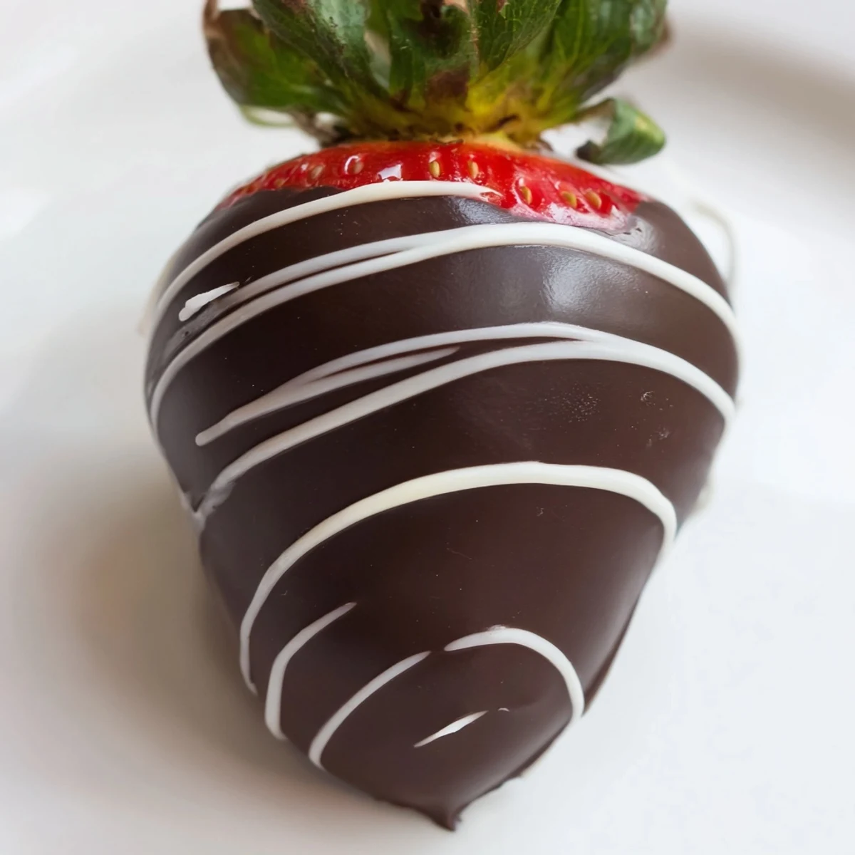 Artfully plated chocolate dipped strawberries with white chocolate drizzle, perfect for Valentine’s Day, parties, or an elegant sweet treat.