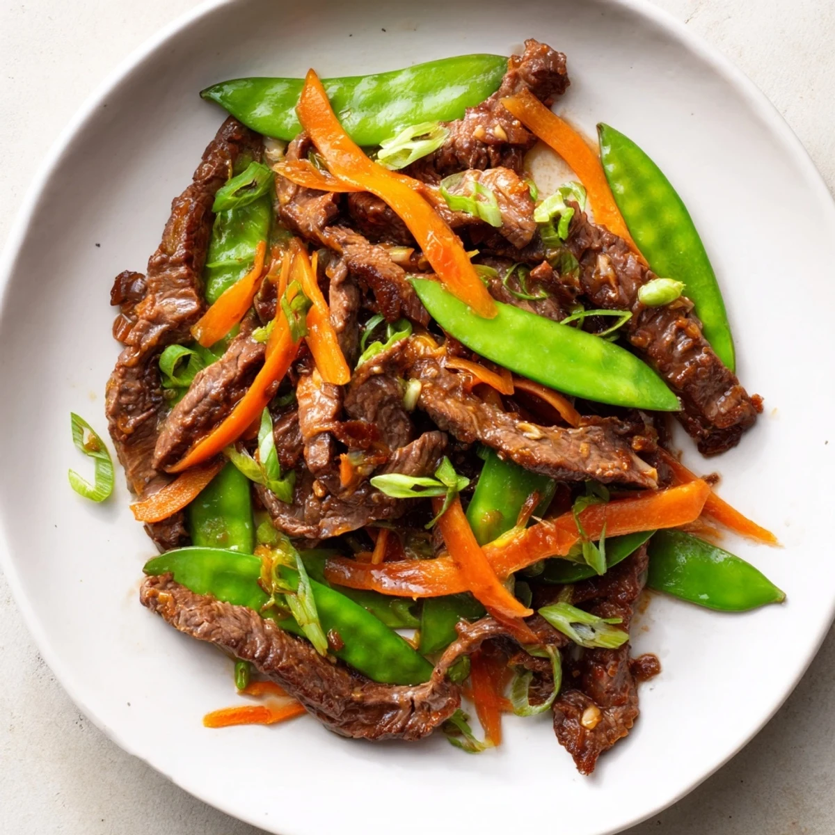 Beef Stir Fry with Snow Peas and Carrots sizzling in a wok, ready to serve over steamed rice for dinner.