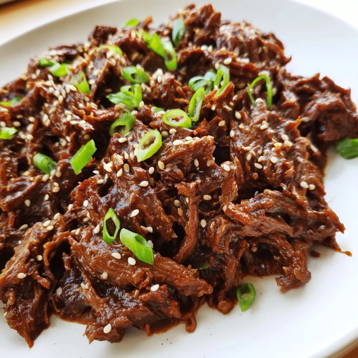 A slow cooker filled with tender Crock Pot Korean Beef garnished with green onions, paired with kimchi and steamed broccoli.
