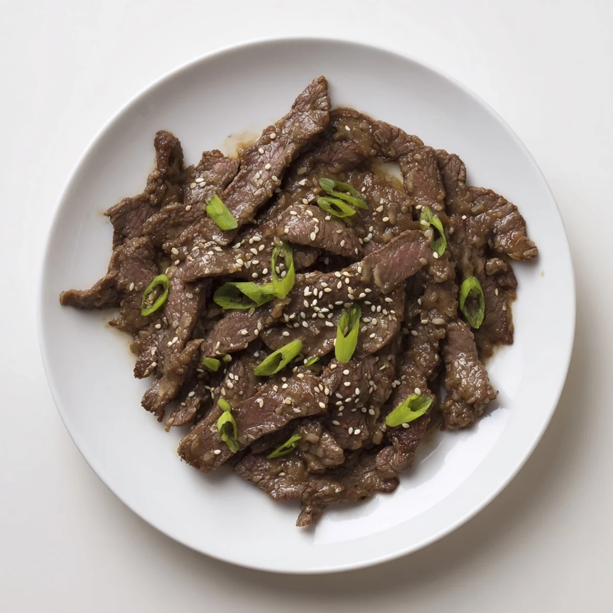 Sizzling Ultimate Slow Cooker Mongolian Beef in a serving bowl, paired with fluffy rice and vibrant green onions for a cozy Chinese-American weeknight meal.