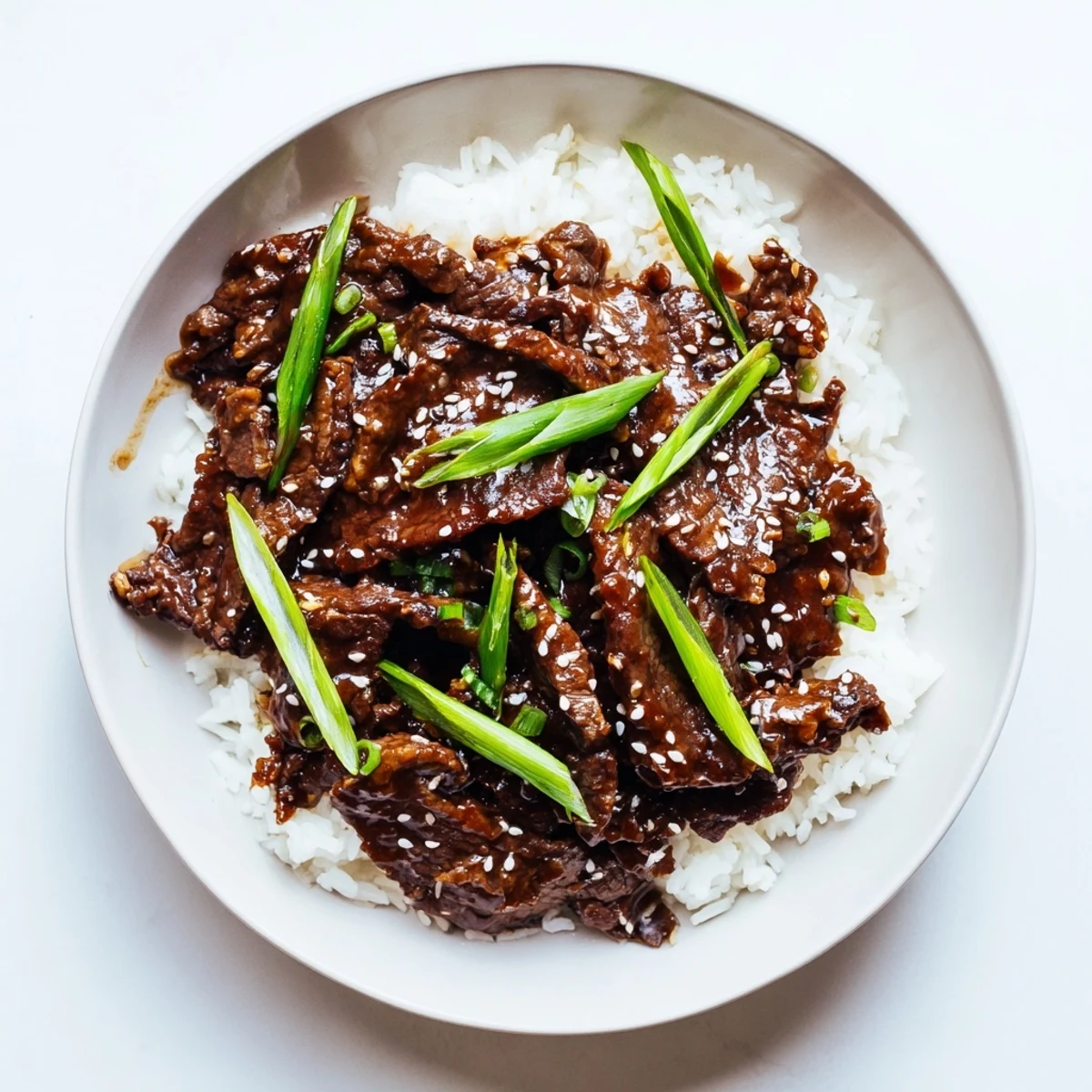 Savory Ultimate Slow Cooker Mongolian Beef served with steamed rice and toasted sesame garnish.