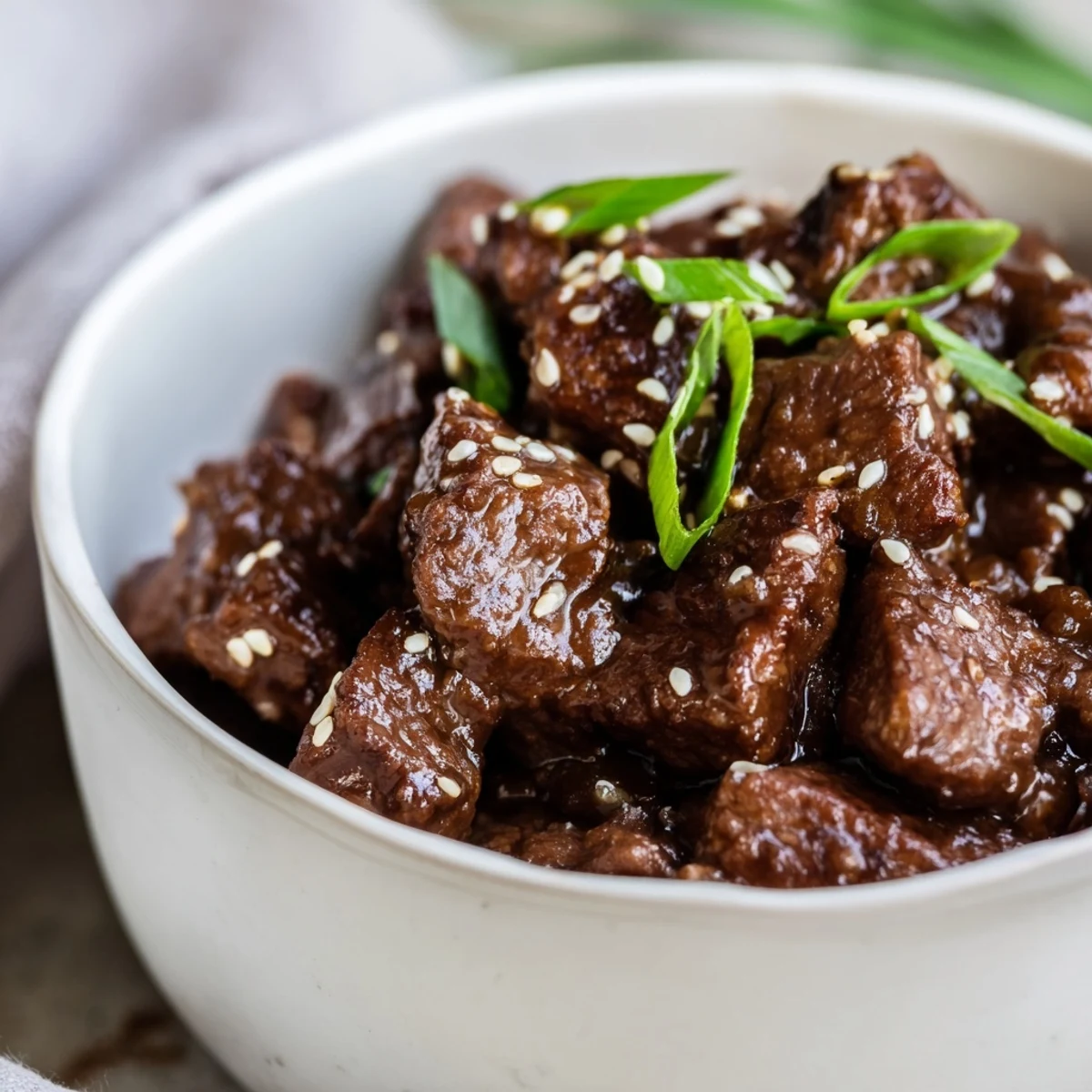 Slow-cooked Crock Pot Korean Beef in a glossy, spicy sauce, garnished and piled onto plates.