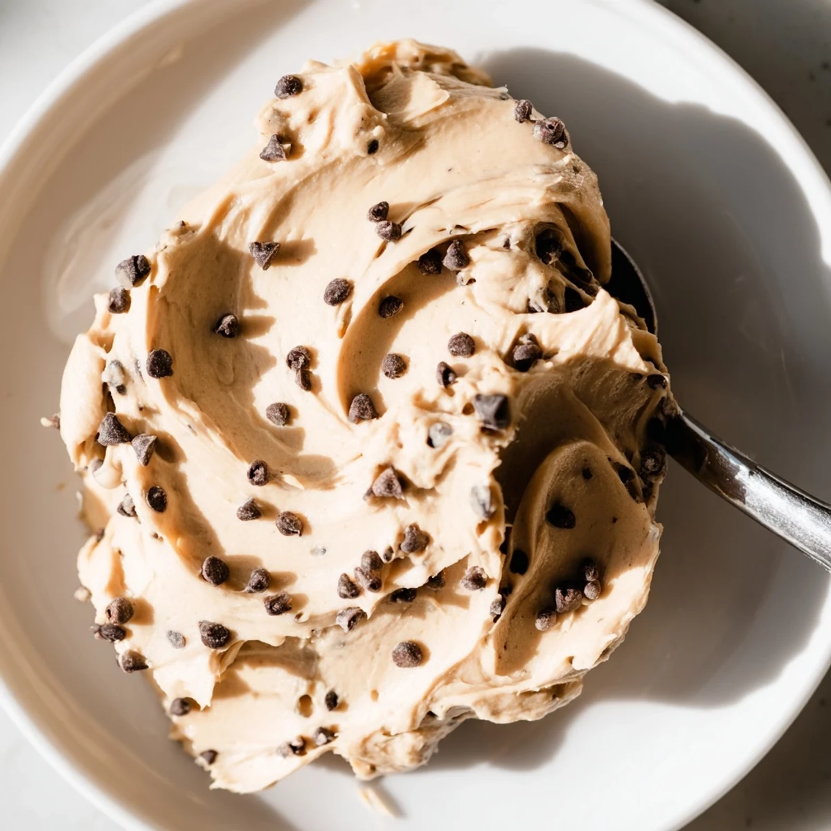 The creamy Cookie Dough Frosting on cupcakes has mini chocolate chips and a soft, doughy texture.
