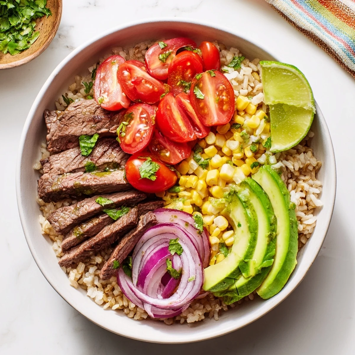 This vibrant bowl showcases the Steak Avocado Roasted Corn Bowl with fresh cherry tomatoes, red onion, cilantro, and a zesty lime dressing drizzle.