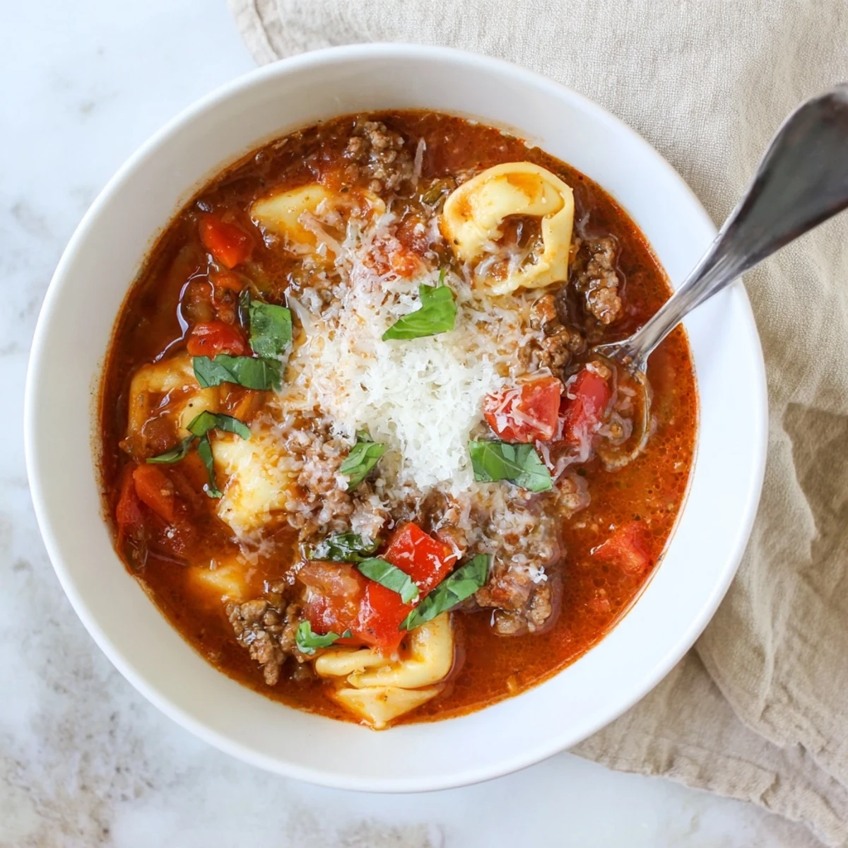 Delicious Lasagna Soup with Tortellini garnished with parsley, ready to serve alongside a glass of Chianti on a rustic table.