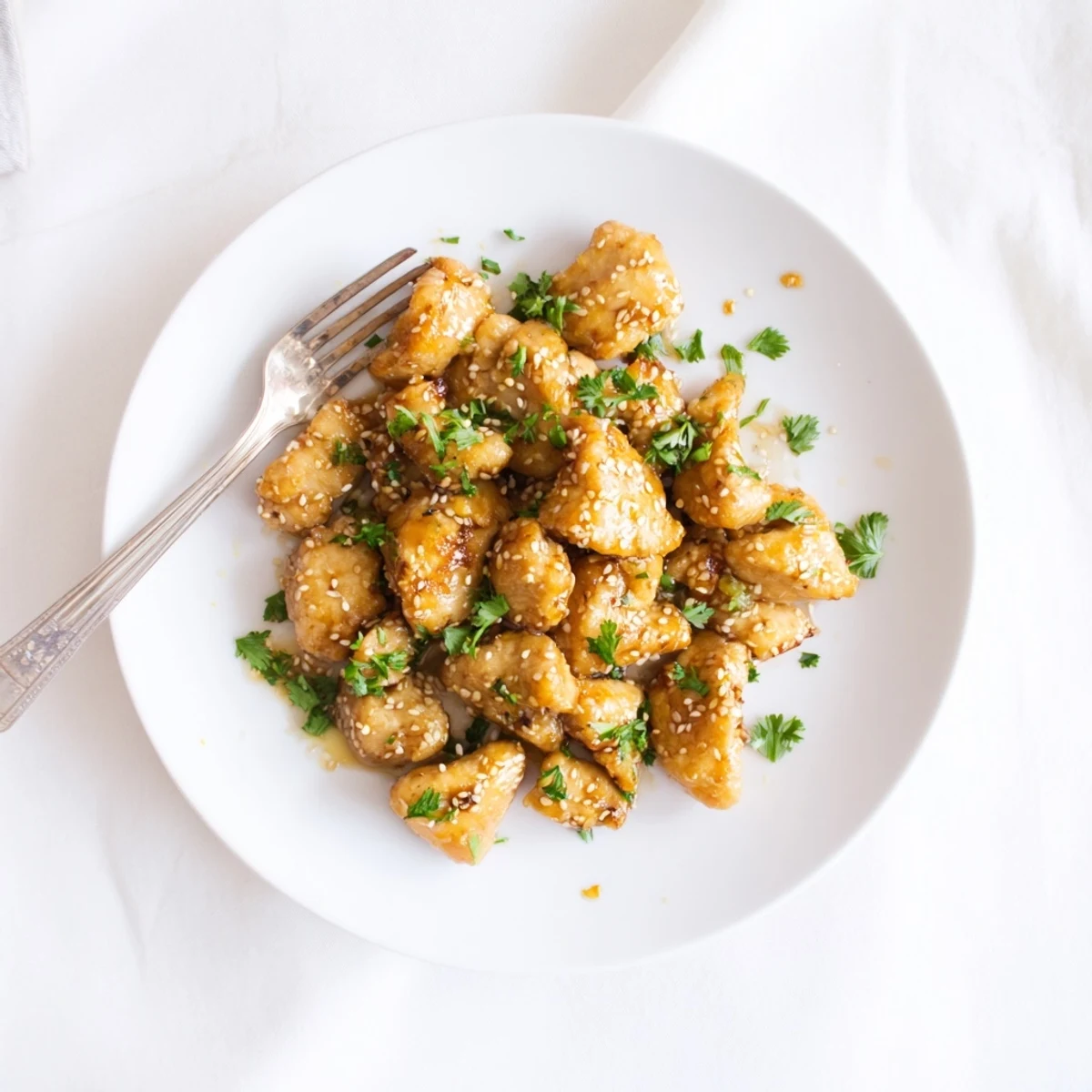 Honey Butter Chicken in a skillet with a warm honey butter sauce, steam rising and sesame seeds sprinkled on top.
