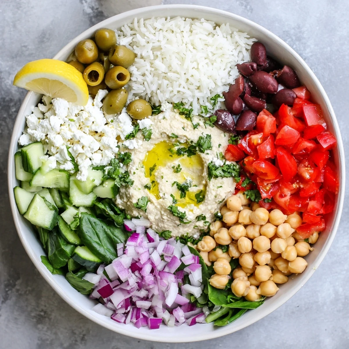 Nourishing Mediterranean rice bowl featuring chickpeas, bell peppers, spinach, and tahini dressing garnish