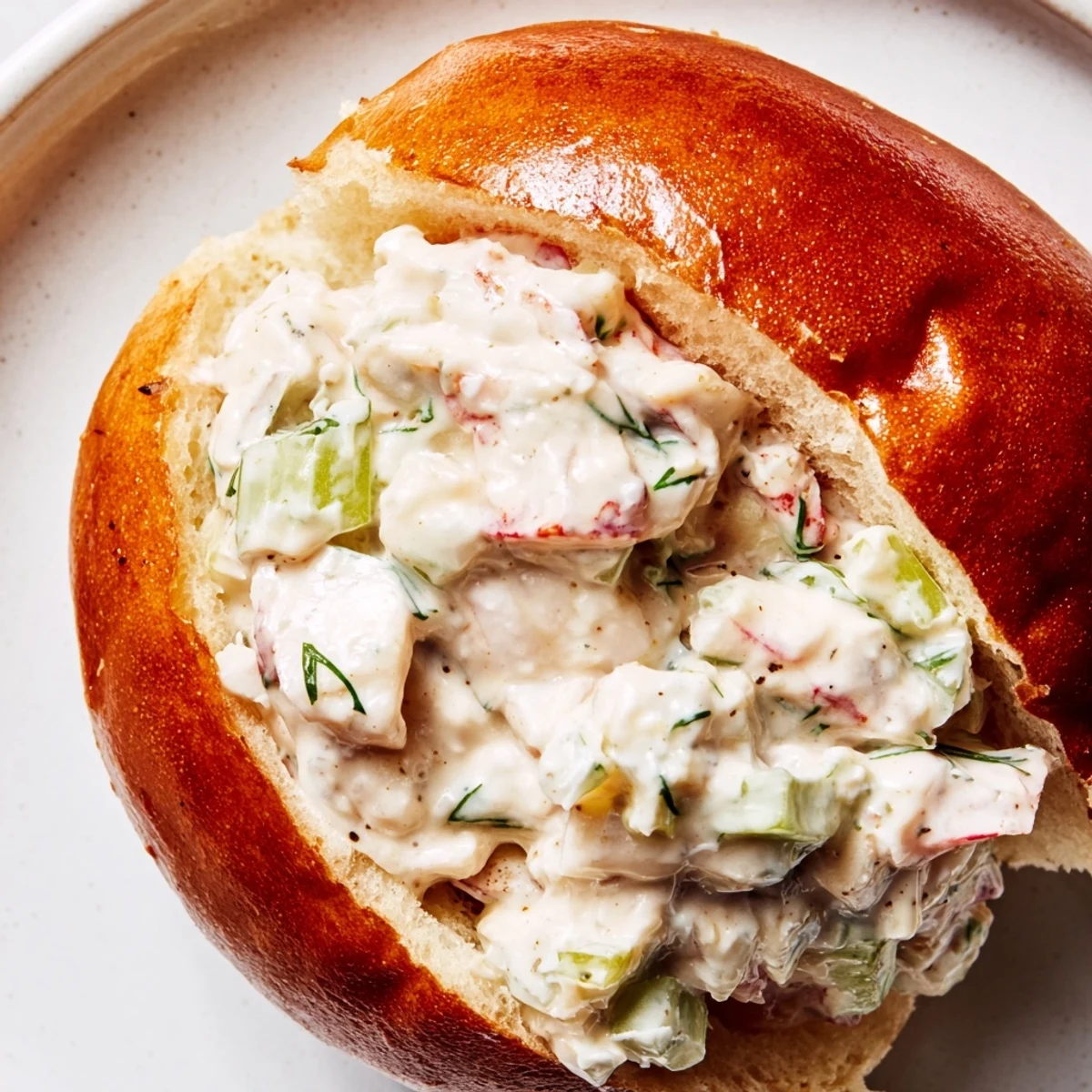 Golden toasted brioche roll piled high with creamy garlic butter lobster rolls and fresh herbs