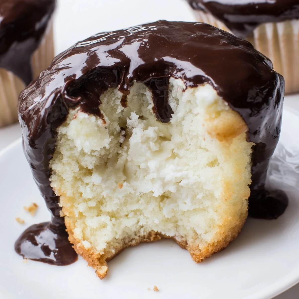 Classic Boston cream pie cupcakes with pastry cream filling and chocolate dripping down sides