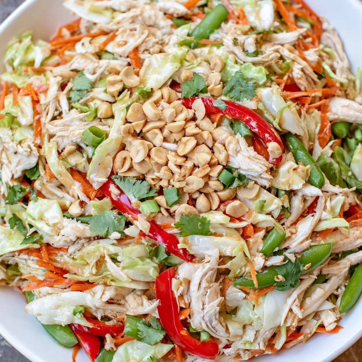 Fresh Asian chicken salad featuring rotisserie chicken, Napa cabbage, carrots, and crunchy peanut toppings
