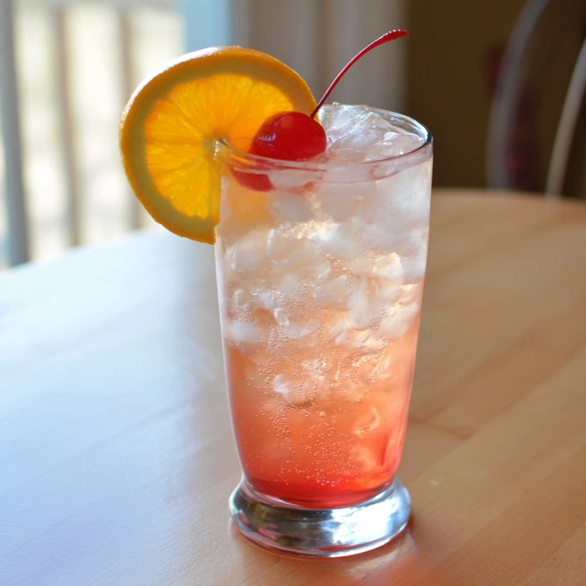 Classic Easy Shirley Temple Drink showing rosy pink color from grenadine syrup, sparkling carbonation, and cherry topping