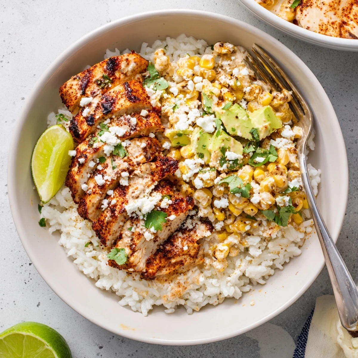 Vibrant street corn chicken rice bowl featuring charred corn, juicy spiced chicken, and creamy cotija sauce