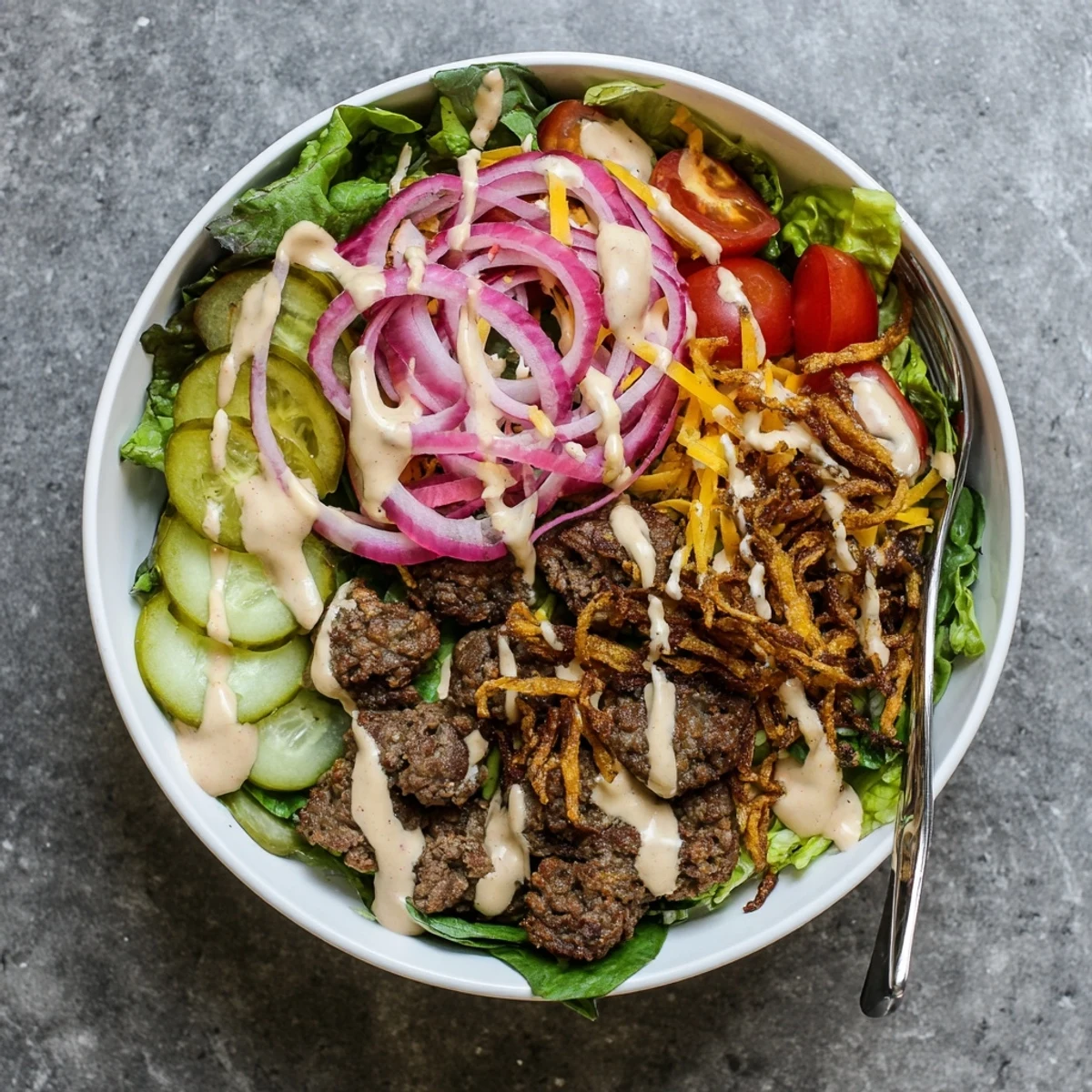 Low-carb smash burger bowl served with crispy beef patties fresh veggies pickles and creamy house sauce