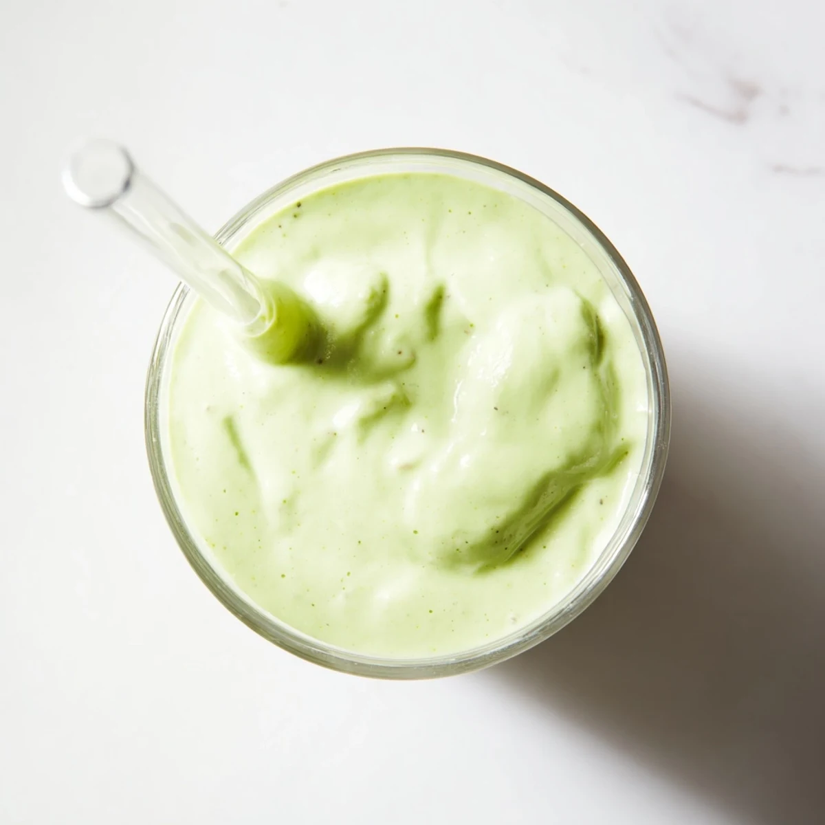 Blender filled with bright green Greek yogurt avocado smoothie ingredients ready for healthy breakfast