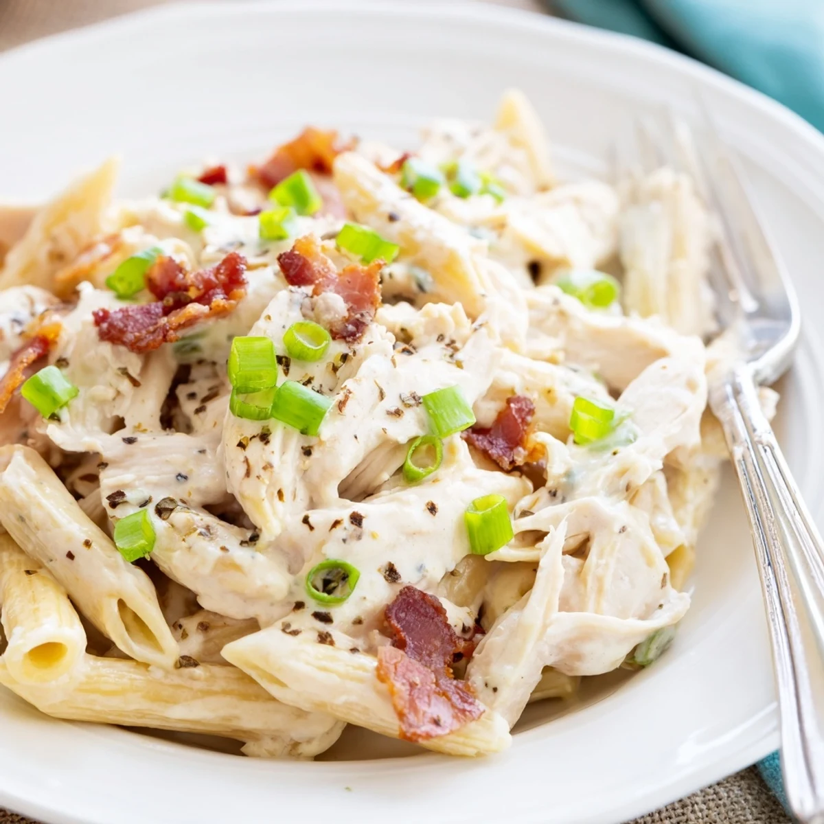 Steaming bowl of crack chicken pasta featuring tender chicken pieces in a velvety ranch cream sauce