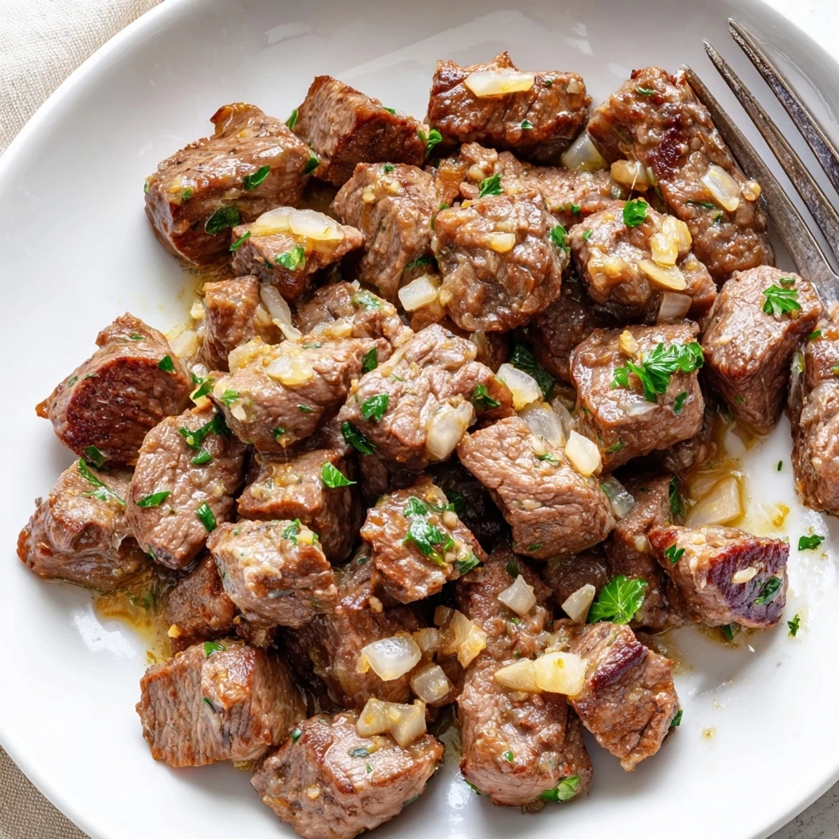 Golden brown crockpot steak bites coated in rich Worcestershire garlic butter with onion