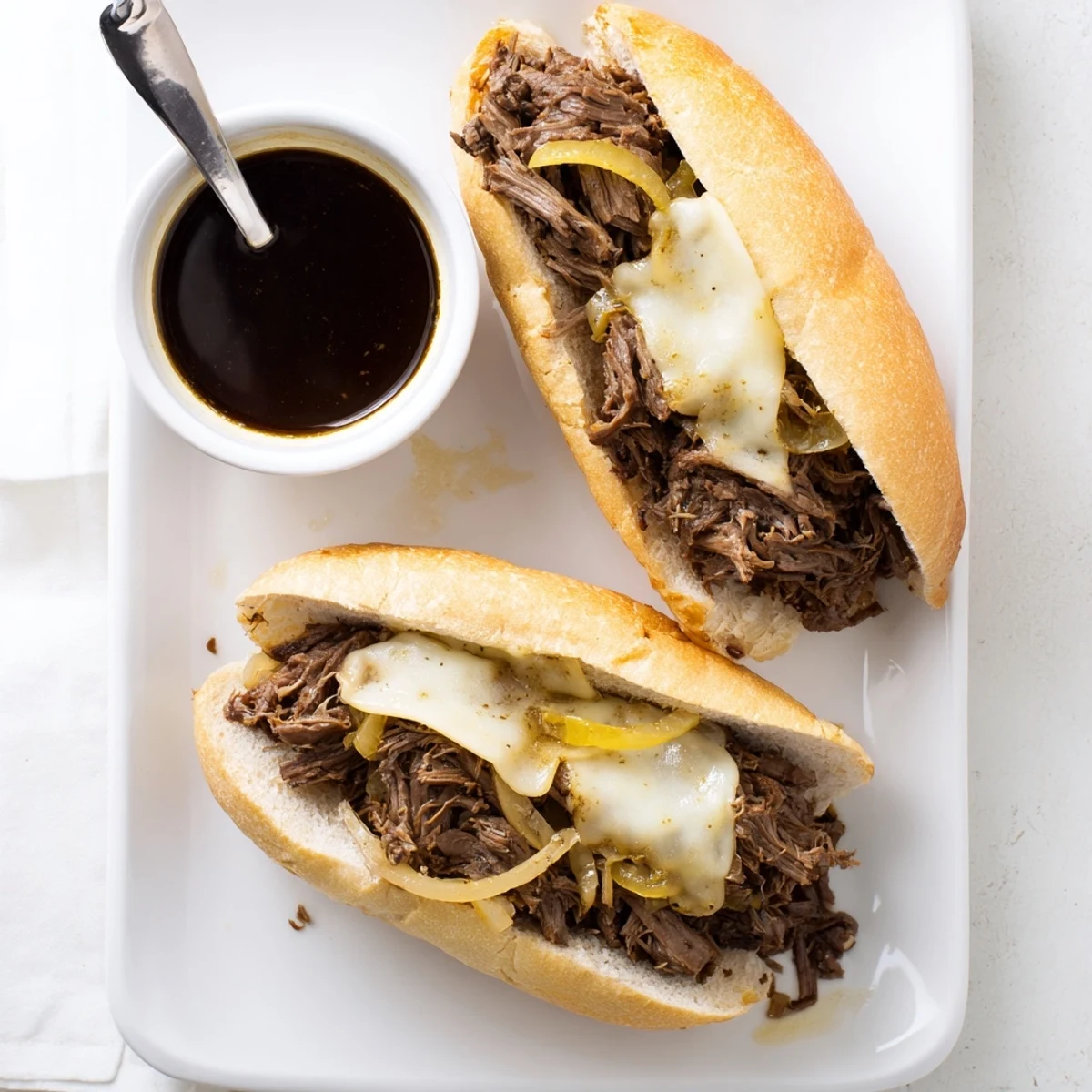 Shredded slow-cooked beef piled on toasted hoagie rolls for these easy Crockpot French Dip Sandwiches
