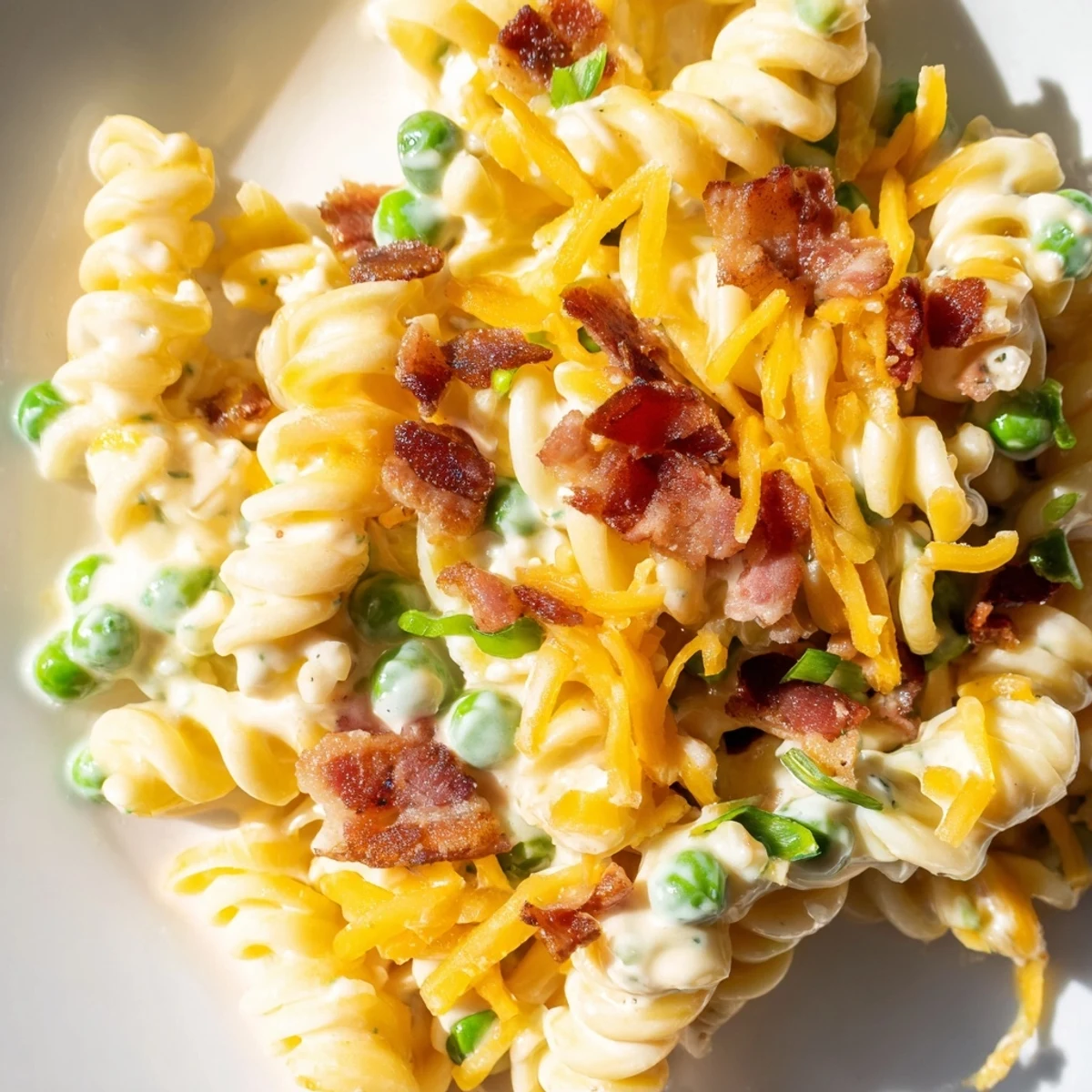 Cold pasta salad loaded with bacon, peas, and cheddar in creamy ranch dressing