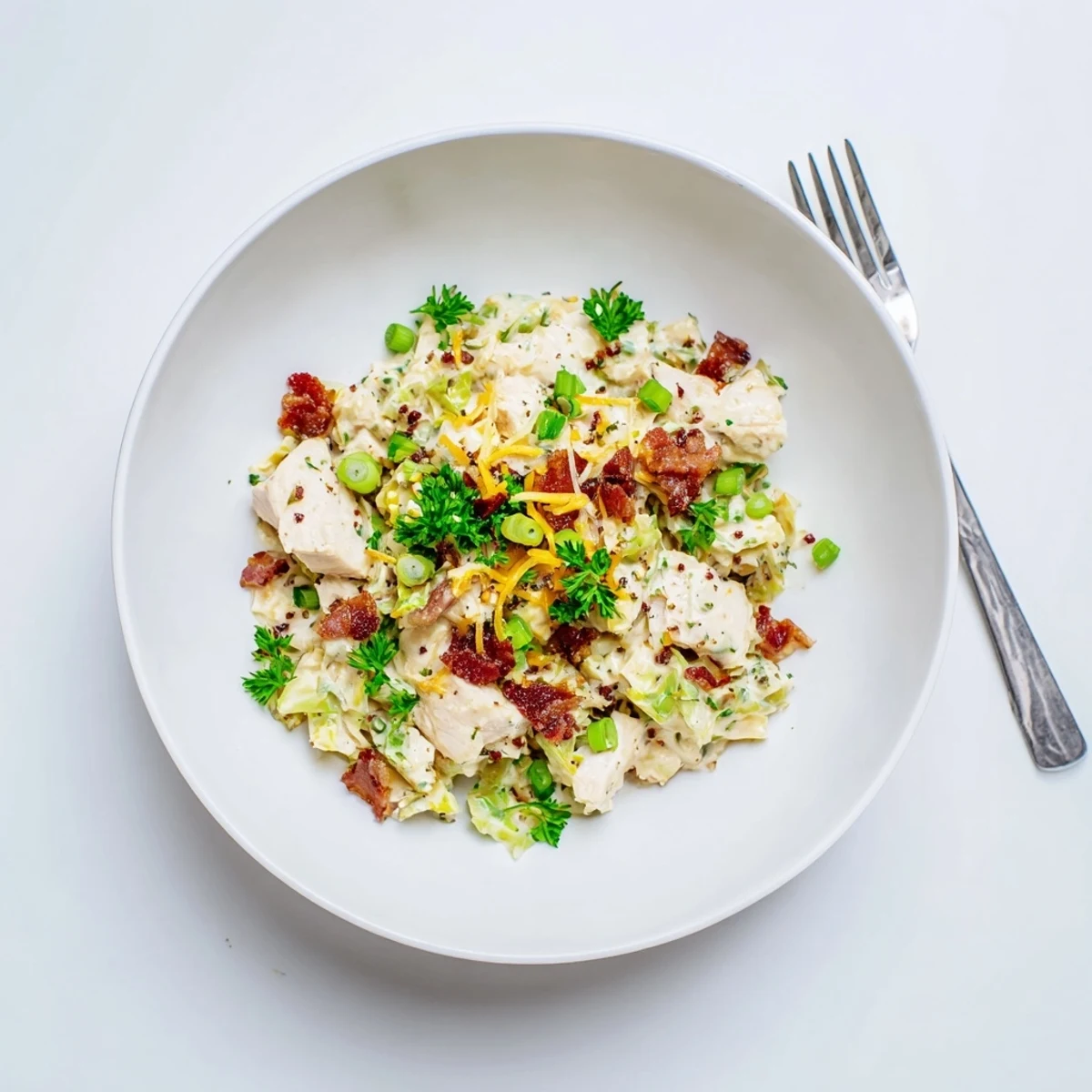 Creamy chicken bacon ranch cabbage bowls topped with melted cheddar and fresh green onions