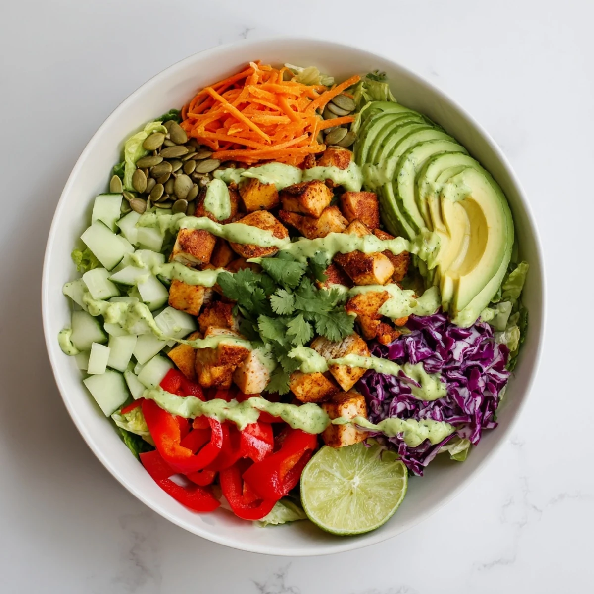 Keto bowls featuring crisp romaine, tender spiced chicken, and vibrant vegetables drizzled with rich avocado sauce