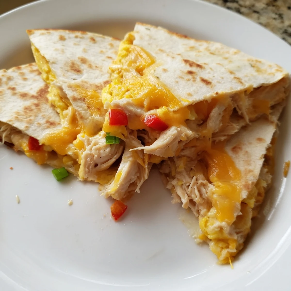 Chicken Breakfast Quesadilla sliced into golden wedges with gooey cheese pull