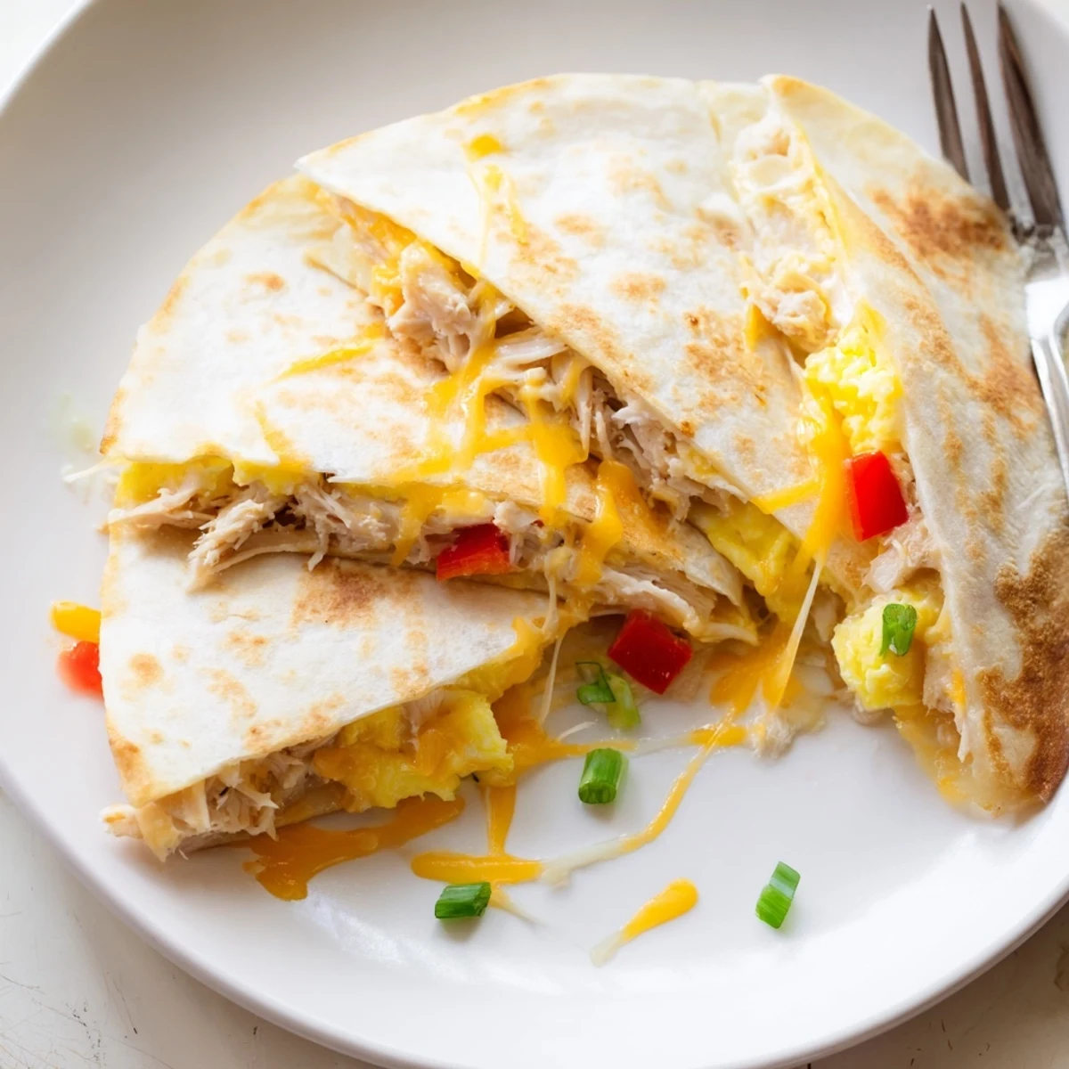Hearty Chicken Breakfast Quesadilla plated with avocado slices and zesty salsa