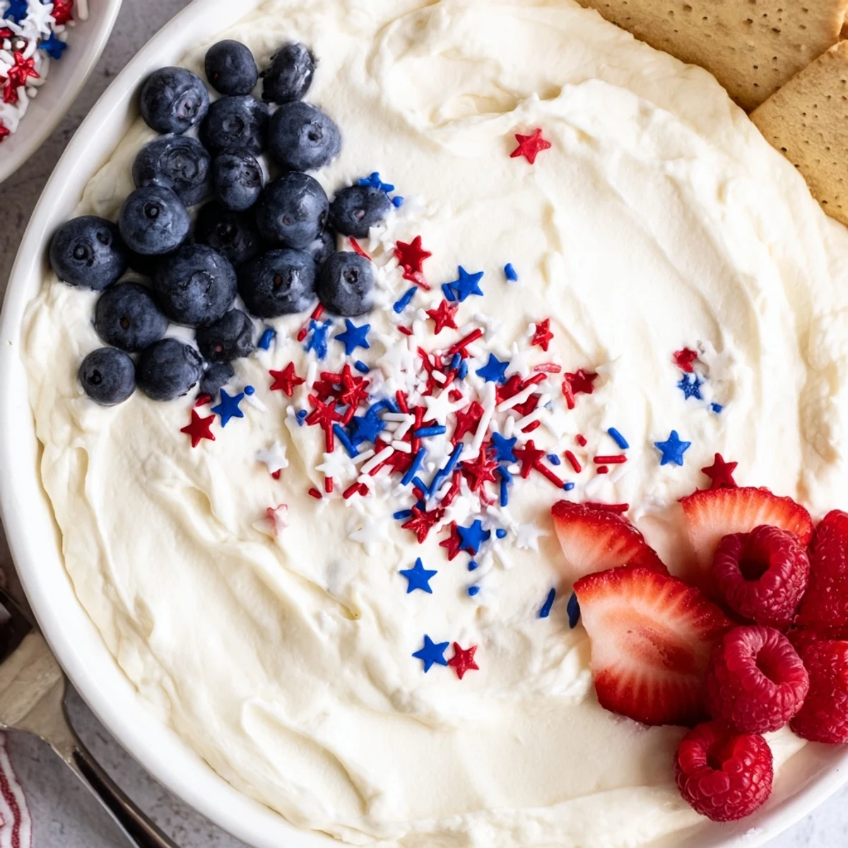 How To Make Star Spangled Cheesecake Dip topped with glossy berries and sprinkles