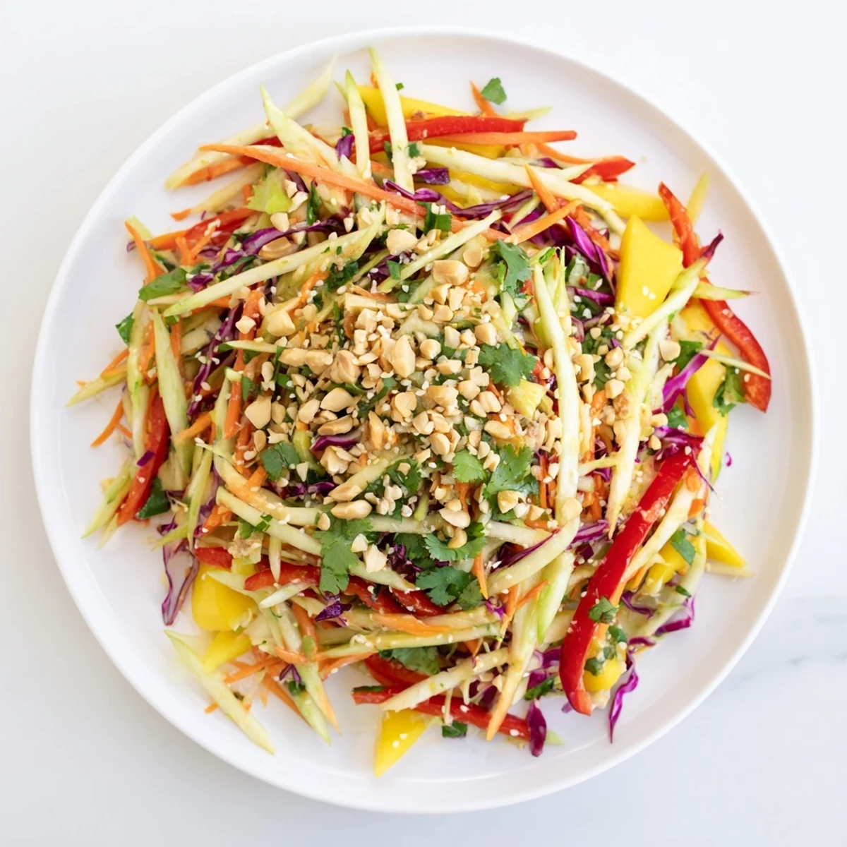 Colorful refreshing mango slaw with red cabbage, carrots, and tangy lime dressing in white bowl