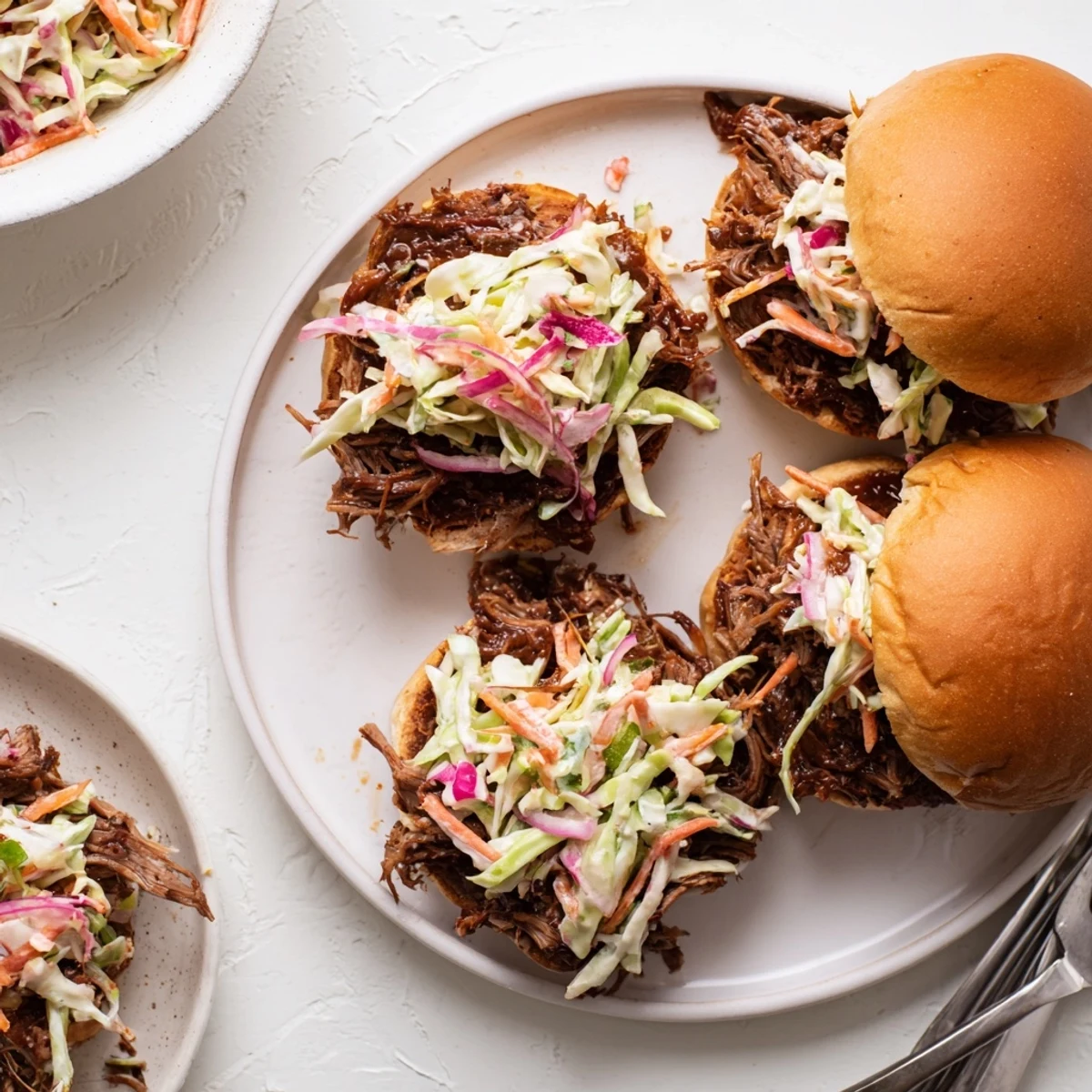 Hearty BBQ pulled beef sliders topped with fresh colorful coleslaw on buttery brioche buns