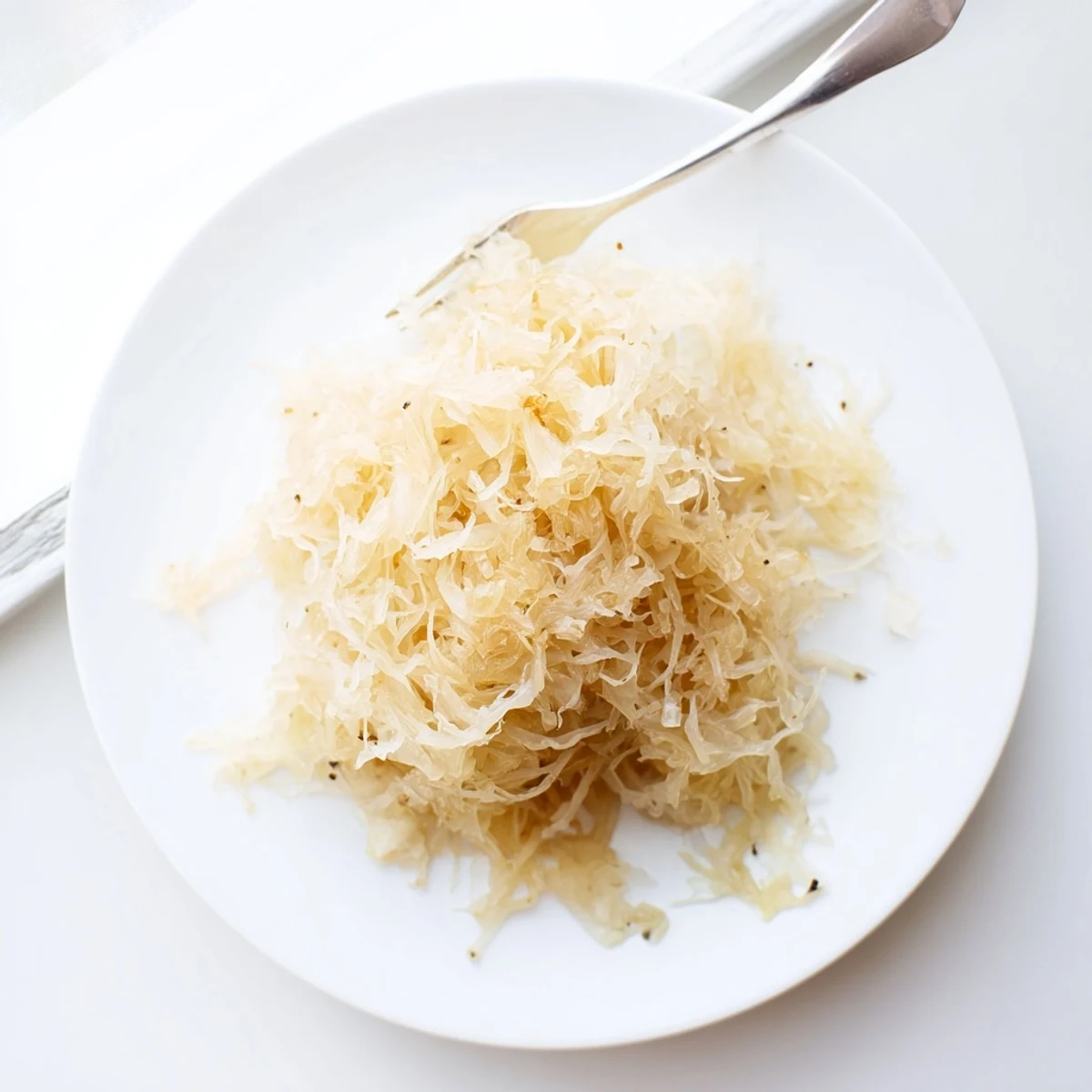 Finely shredded German sauerkraut packed tightly in fermentation crock with submerged cabbage
