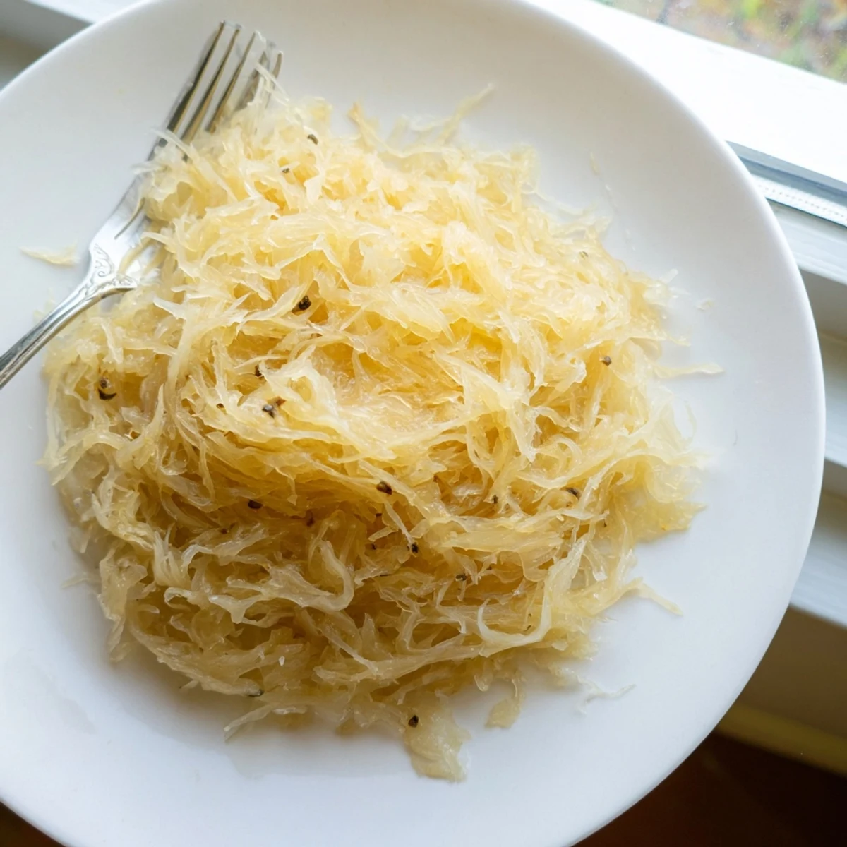 Tangy homemade sauerkraut served alongside bratwurst and mustard on wooden cutting board
