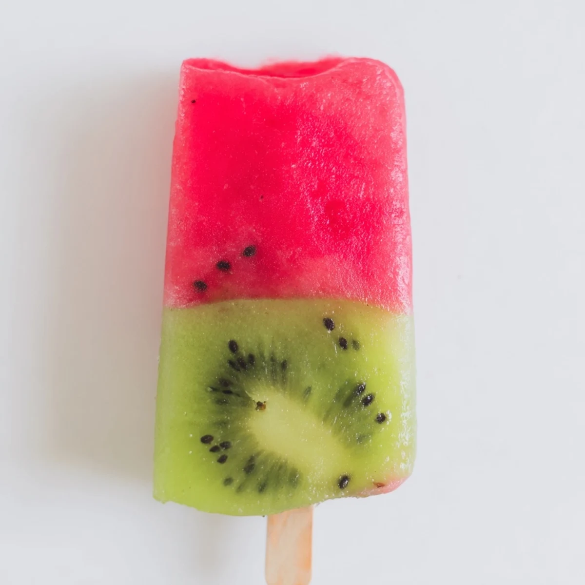 Homemade Watermelon Kiwi Fruit Popsicles showing two-toned fruit layers on wooden sticks