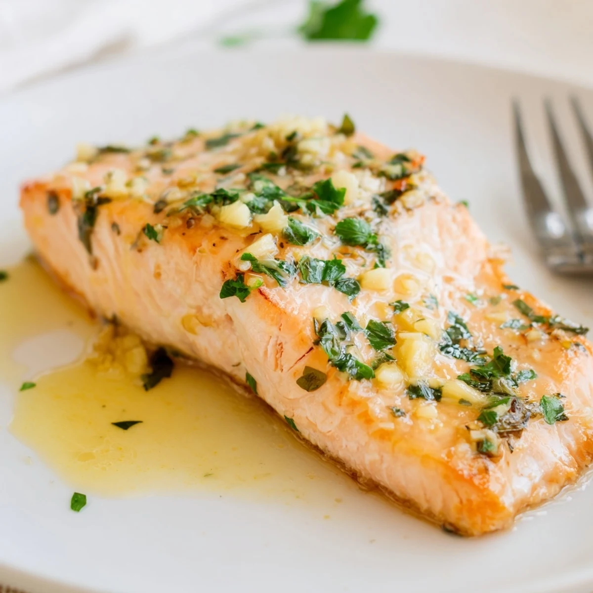 Pan-seared garlic butter salmon topped with fresh parsley and served with lemon wedges