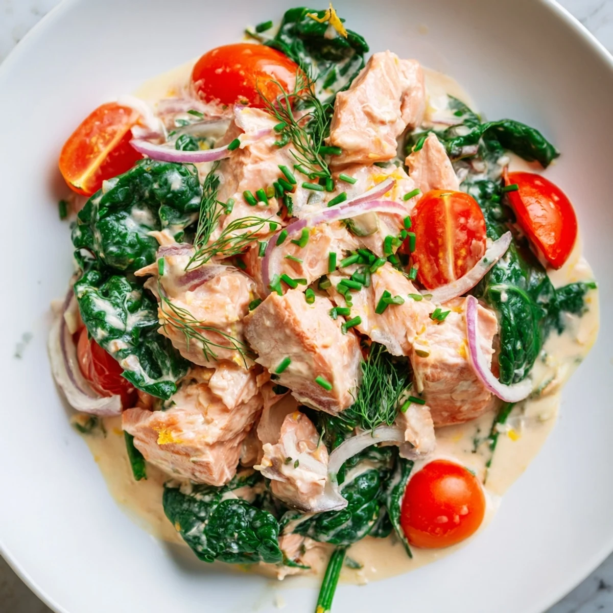 Healthy creamy leftover salmon recipe served steaming in a bowl topped with fresh chives