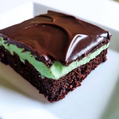 Perfectly set Green Mint Brownies with a vibrant green layer, ready to serve with coffee on a cozy kitchen counter.