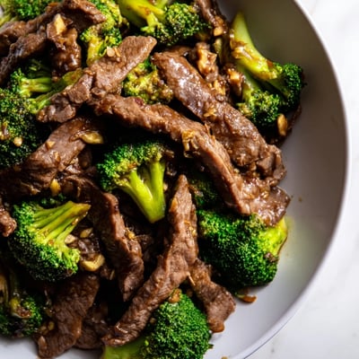 Freshly stir-fried Beef and Broccoli with Soy Sauce steaming in a hot wok, showcasing tender meat and crisp greens in a rich, aromatic glaze.